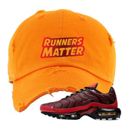 embroidered on the front of the air max plus sunburst sneaker matching orange distressed dad hat is the runners matter logo