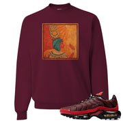 printed on the front of the air max plus sunburst sneaker matching maroon crewneck sweatshirt is the vintage egyptian logo